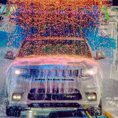 Car in Tidal Wave Auto Spa tunnel with bright colorful lights and water falling