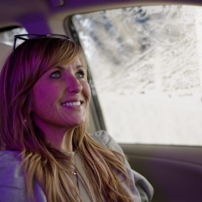 A customer inside a vehicle at Tidal Wave Auto Spa, a car wash, during an automatic wash cycle.